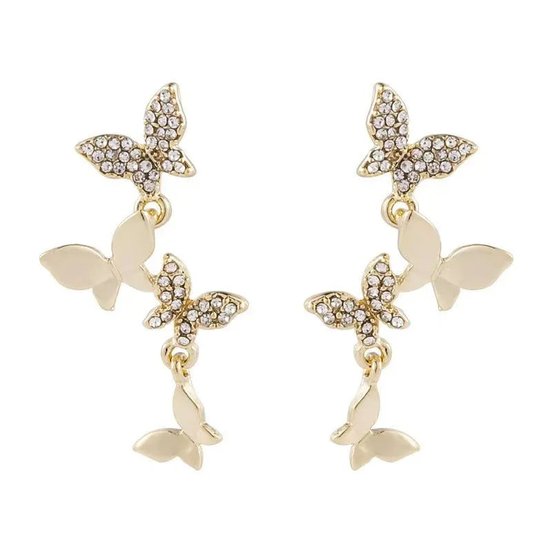 Women's gold copper butterfly drop earrings showing four-element dangle design