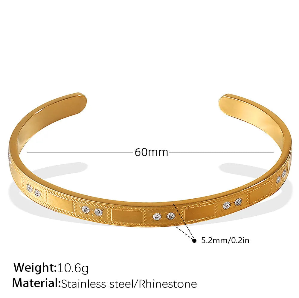 Stainless steel open-end bracelet with a buckle clasp in a choice of gold, silver, or zirconium gold electroplated finishes.