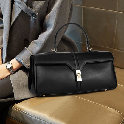 Women's cylindrical cowhide messenger bag in black with multiple internal compartments and shoulder strap