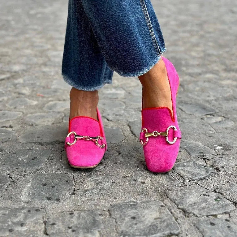 Green suede women's loafers with a round toe and shiny metal buckle fastener on a flat rubber sole.