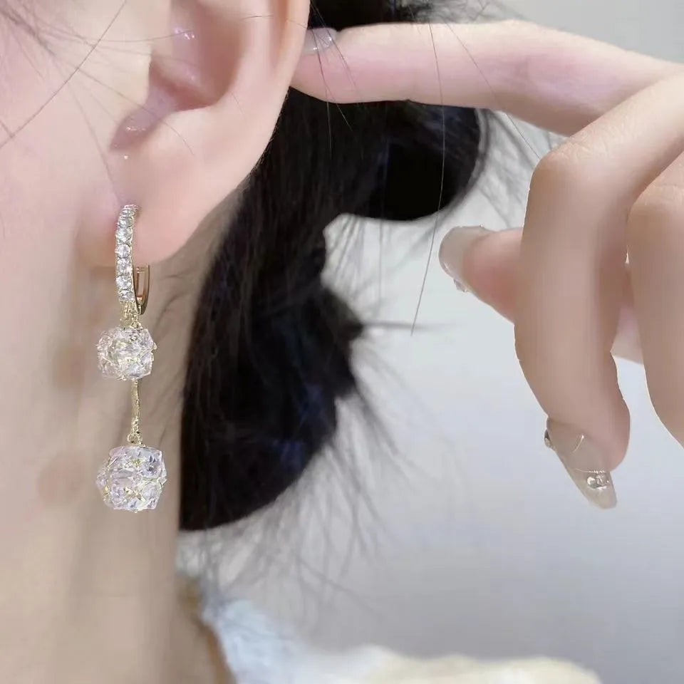 Silver drop earrings with tassel and rhinestone details on copper ear clips