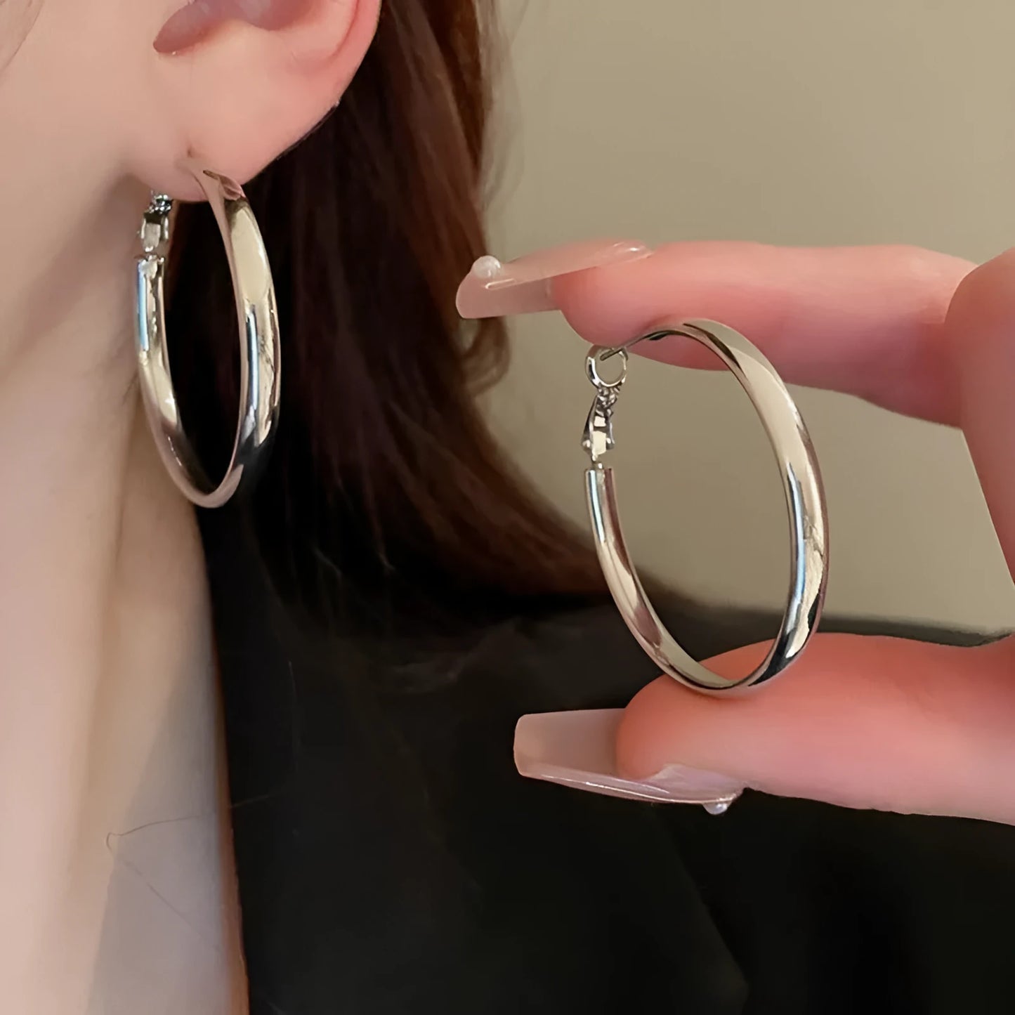 A pair of large, circular metal earrings in gold or silver colour, measuring 40mm.