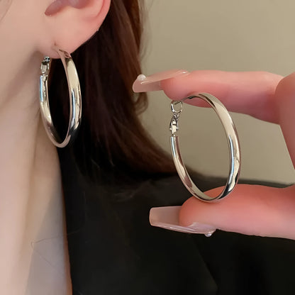 A pair of large, circular metal earrings in gold or silver colour, measuring 40mm.