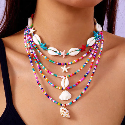 Five women's necklaces with starfish shell beads on adjustable chains in summer colours