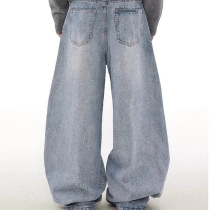 Man wearing retro blue washed straight leg distressed jeans with a mid-rise waist.