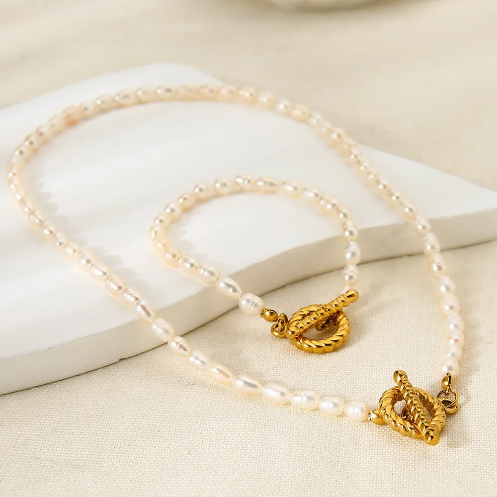 Freshwater pearl and stainless steel geometric pendant necklace with matching bracelet set.