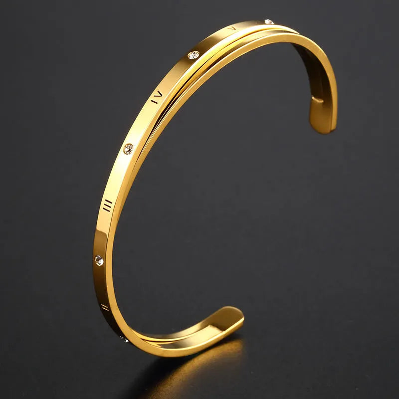 Open-ended women's bracelet with inlaid zircon stones on a stainless steel band in a gold colour finish.