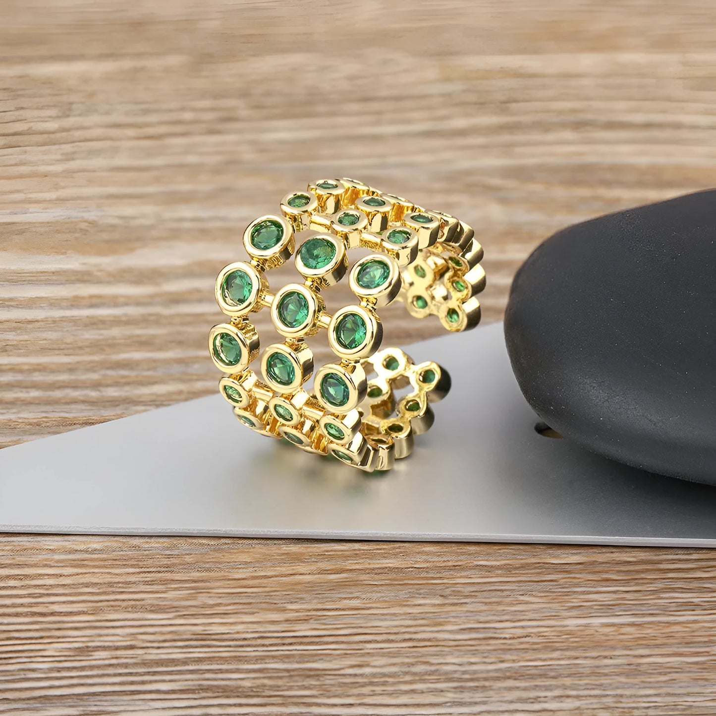 Wide gold-plated copper ring with three-layer design and a large green zircon stone.