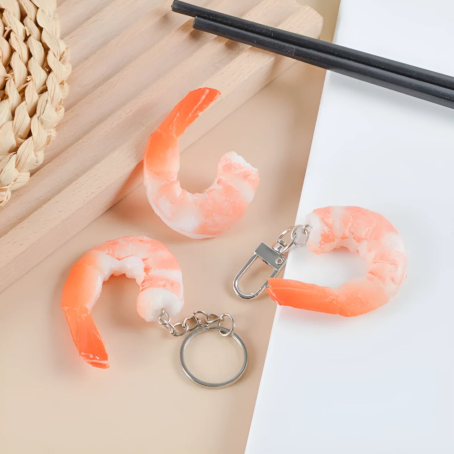White PVC shrimp-shaped keychain with door buckle on a blue background.