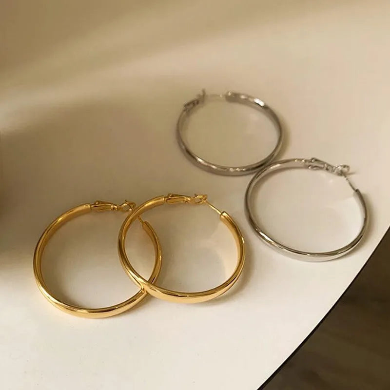 A pair of large, circular metal earrings in gold or silver colour, measuring 40mm.