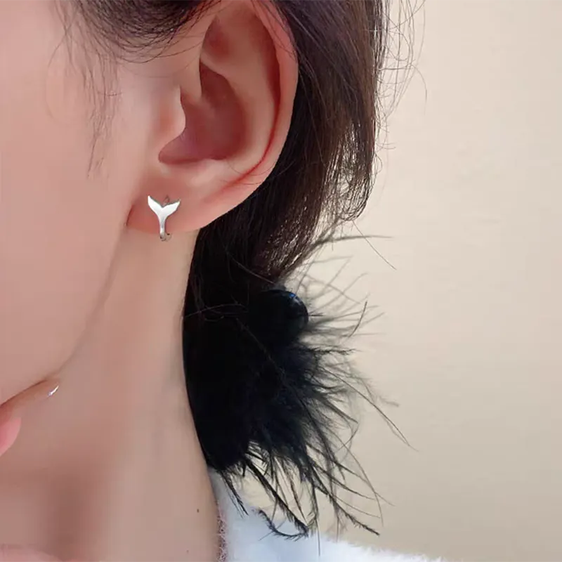 A pair of simple fishtail design earrings with an electroplated metallic finish, shown in white gold and yellow gold colour options.