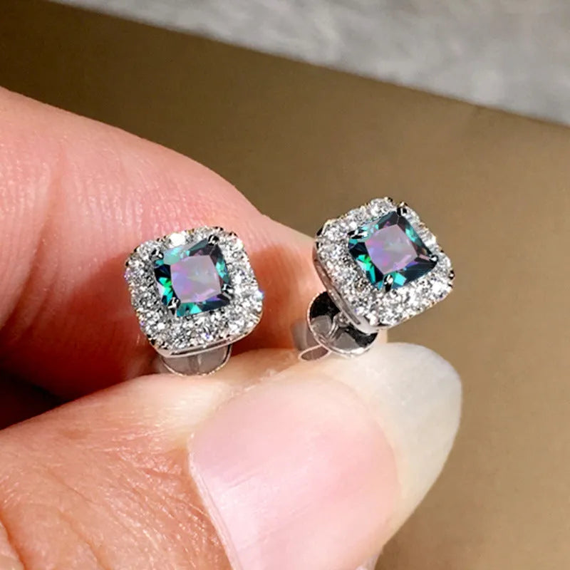 A pair of square cut grandmother green zircon stud earrings with a gold electroplated finish on a white background.