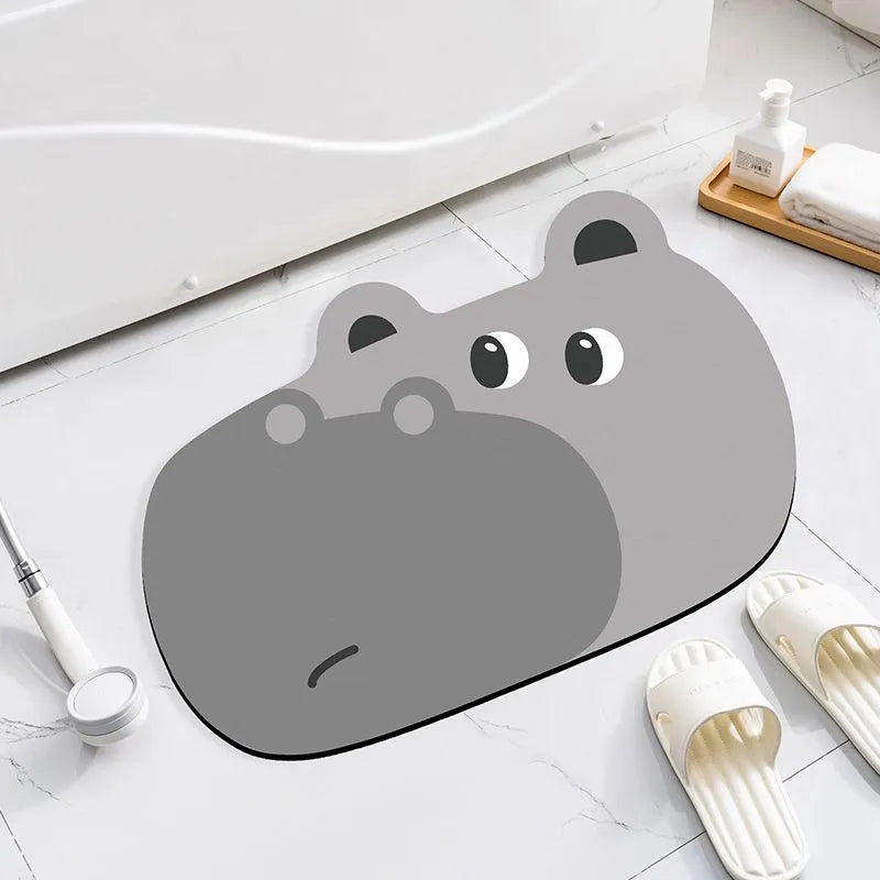 Alien-shaped diatomaceous earth bathroom mat with a cartoon hippo design on a tiled floor.