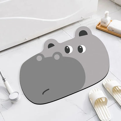 Alien-shaped diatomaceous earth bathroom mat with a cartoon hippo design on a tiled floor.
