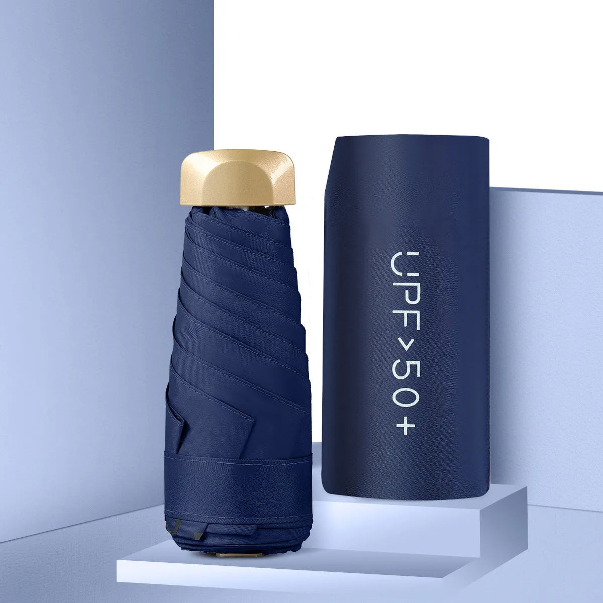 Compact flat-folded sun umbrella in a solid colour, shown next to a hand for scale.