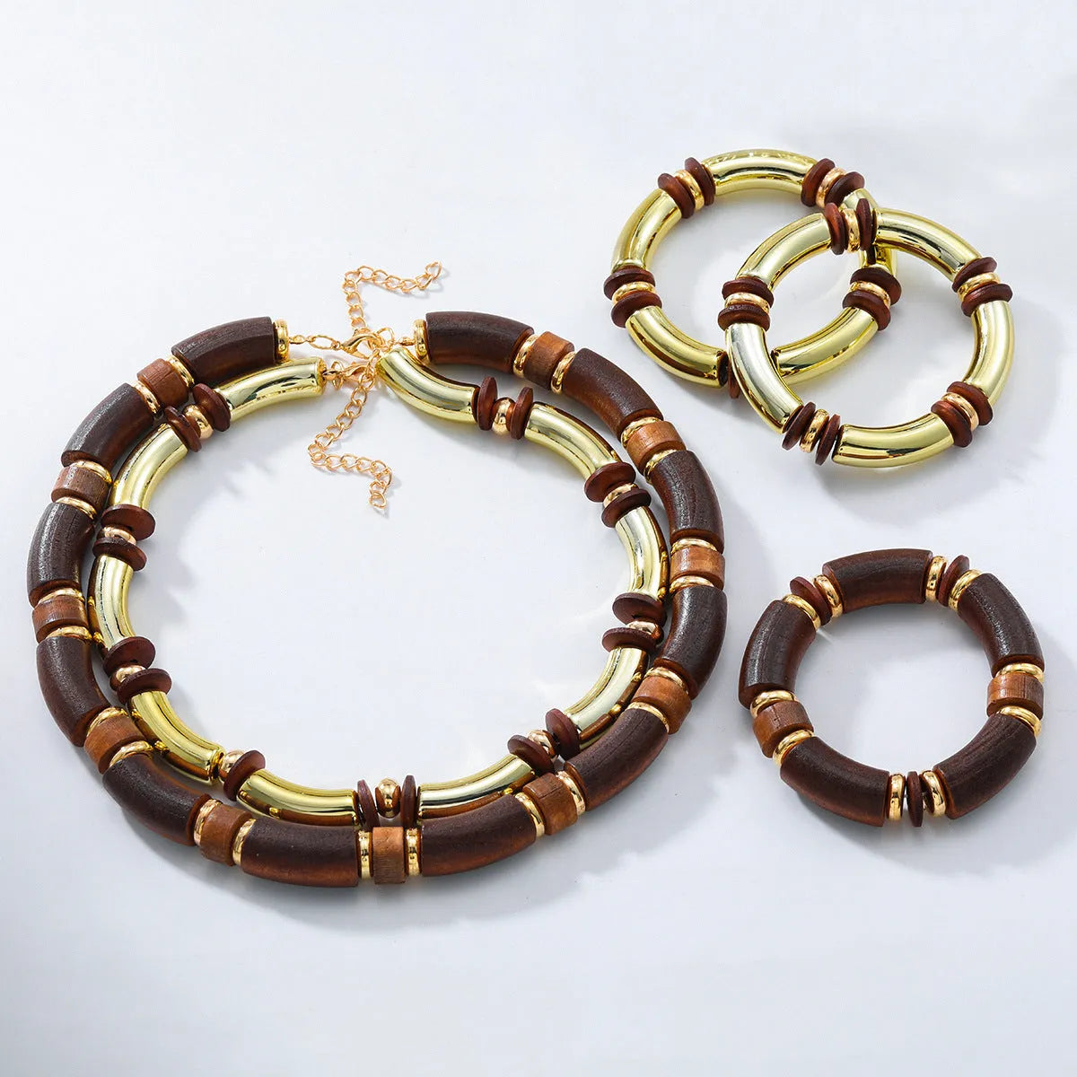 Layered bohemian jewellery set with a large round wooden pendant necklace and matching bracelet on a table.