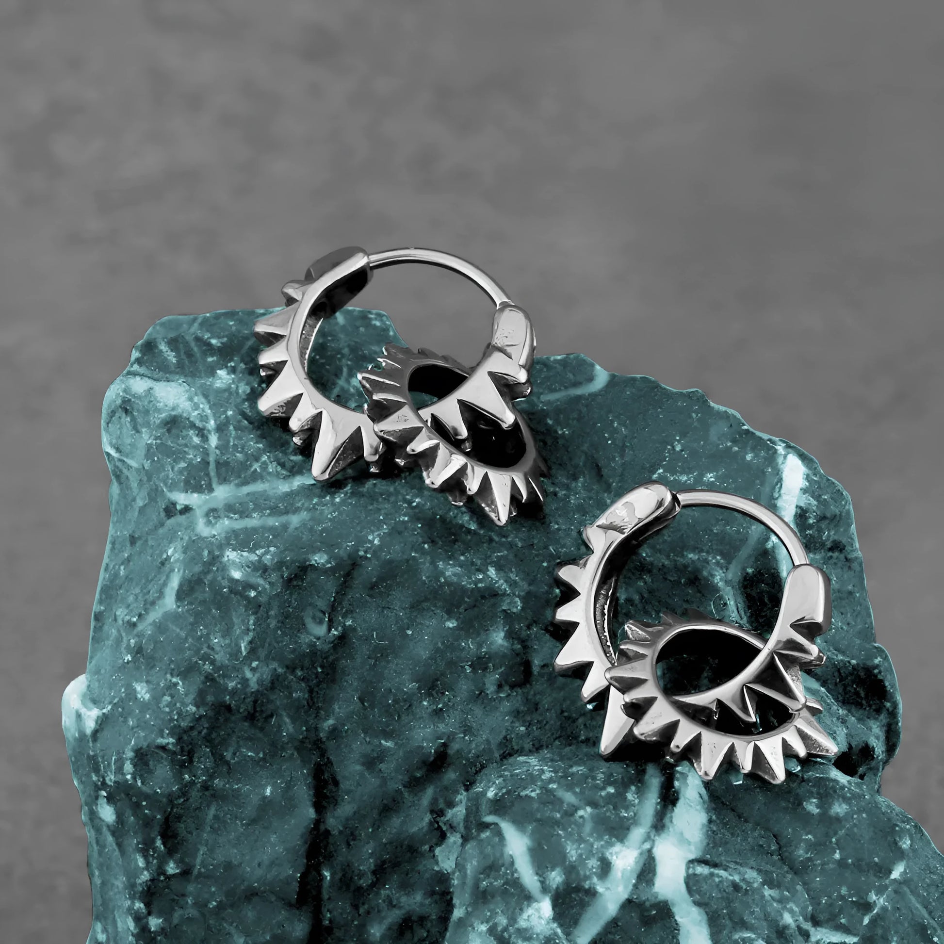 Polished steel round hoop earrings with a 2.5cm diameter on a plain background.