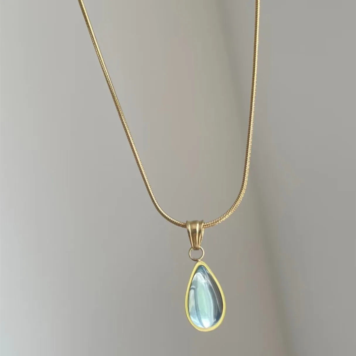 Retro blue and green water drop necklace with gem inlay on a silver titanium steel snake chain.