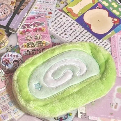Honeydew Roll Plush velvet pencil case with Swiss roll cake design, showing roll-up style and soft texture for stationery storage.