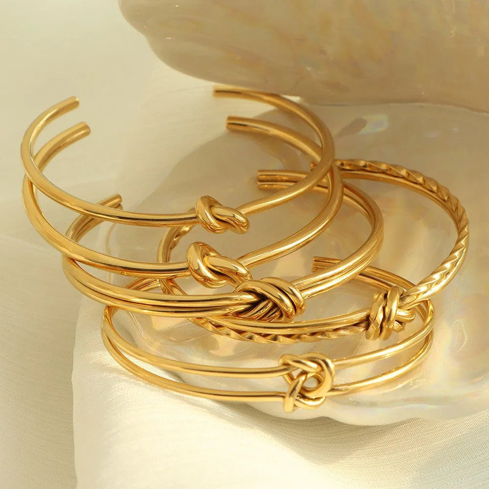 Stainless steel women's bracelet with knotted C-shape open double-layer design in gold or silver.
