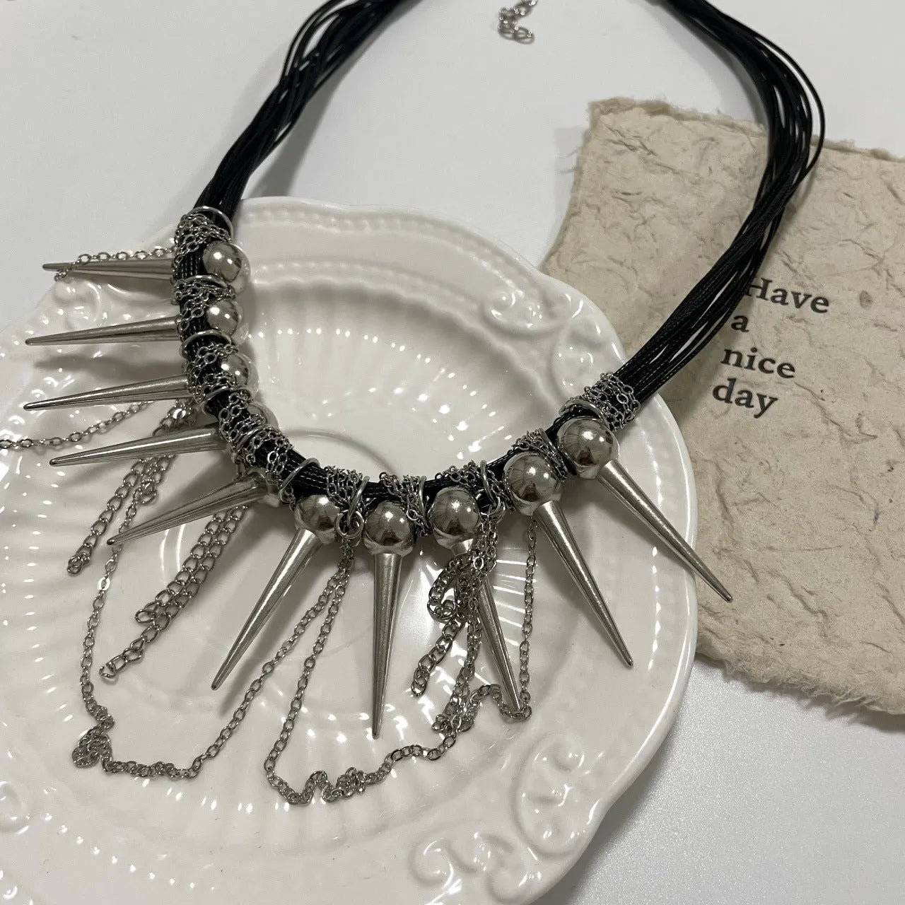 Women's casual leather necklace with winding round beads, a tassel, and decorative point rivets in pictured colour.