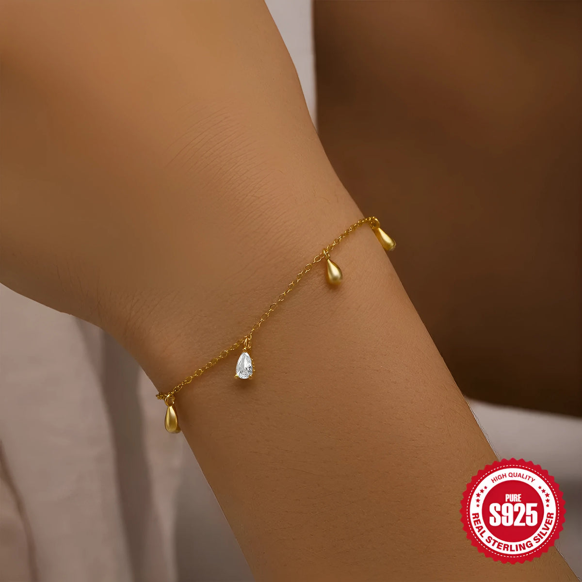 Gold colour sterling silver bracelet with geometric water drop diamond pendant on model wrist