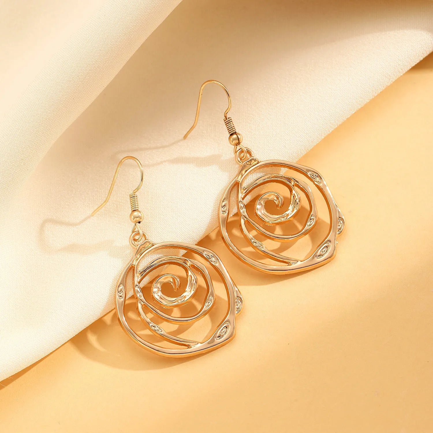 Gold spiral donut alloy jewellery set showing adjustable necklace, matching bracelet, and ear hooks on a plain background.