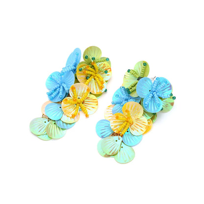 Handmade string bead flower earrings with exaggerated floral shapes in rose and purple colours, showing mixed materials and nickel-free hooks