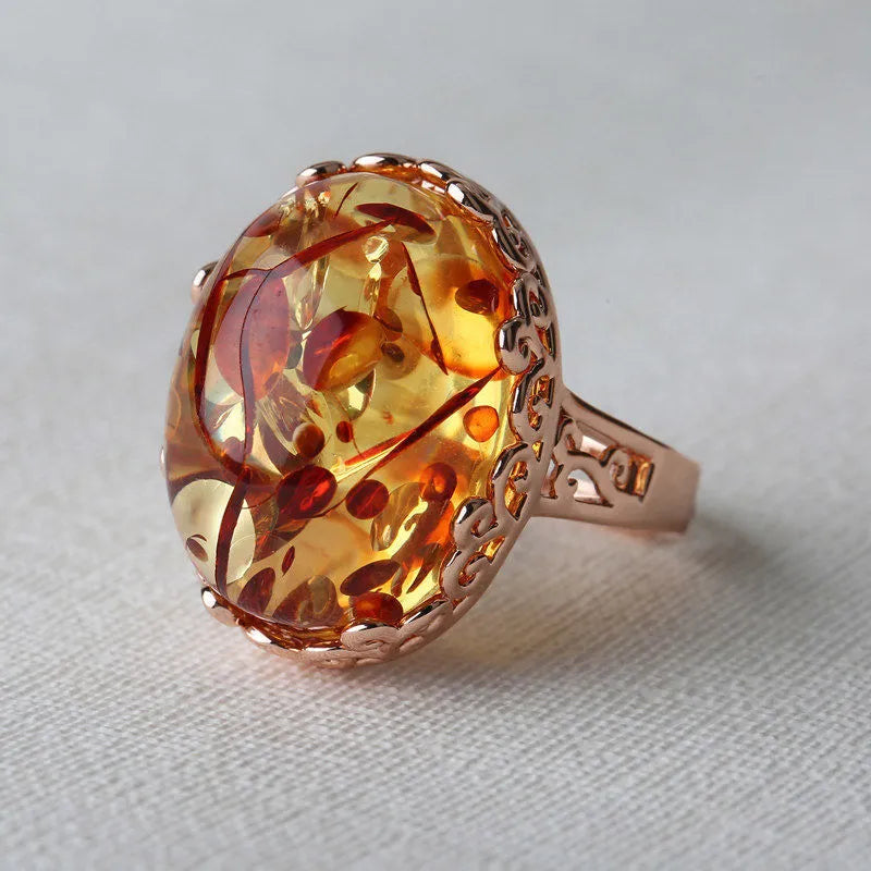 Close-up of a beeswax amber-coloured alloy ring with ethnic retro design on a hand.