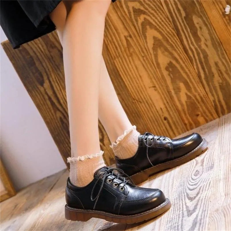 Black retro women's Mary Jane shoes with lace-up front and low square heel on a white background.