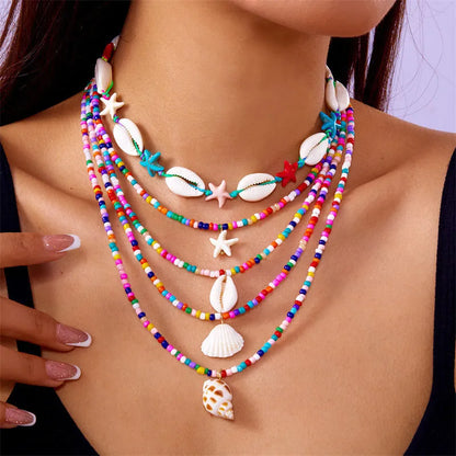 Five women's necklaces with starfish shell beads on adjustable chains in summer colours