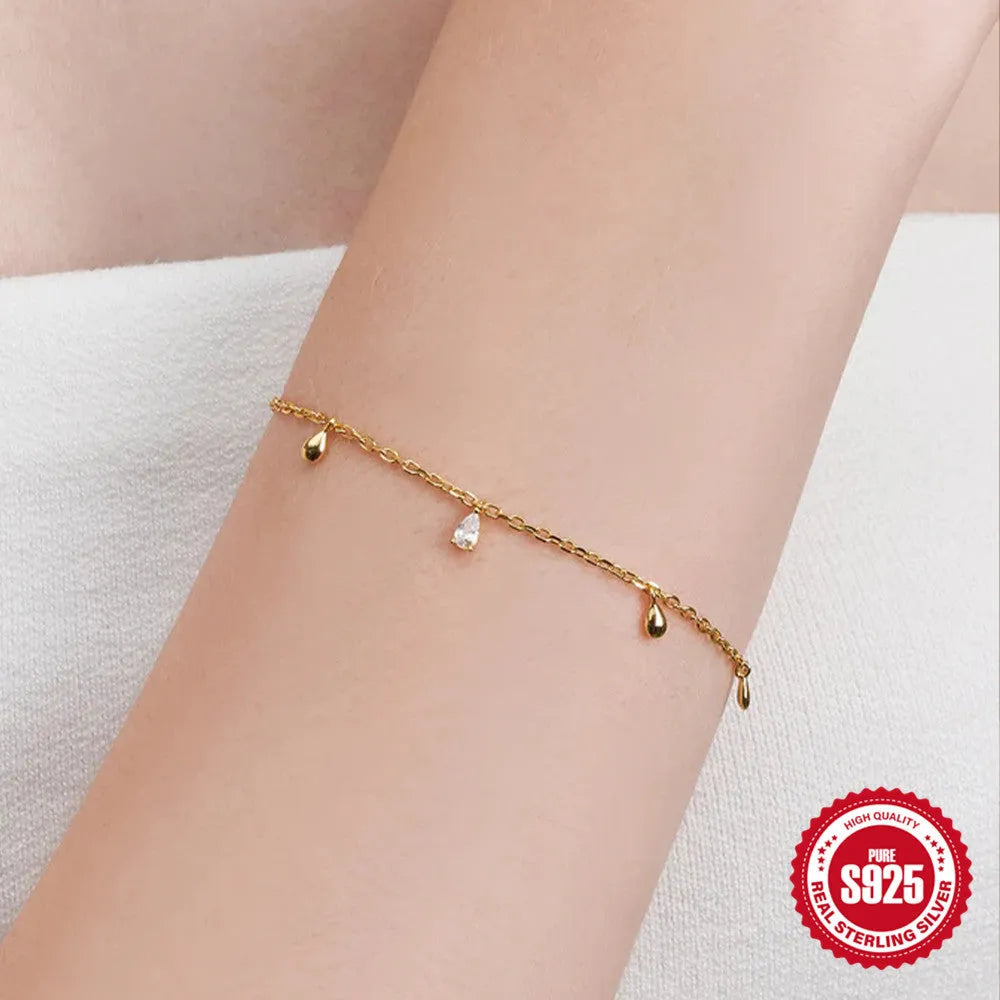 Gold colour sterling silver bracelet with geometric water drop diamond pendant on model wrist
