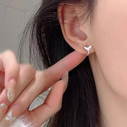 A pair of simple fishtail design earrings with an electroplated metallic finish, shown in white gold and yellow gold colour options.