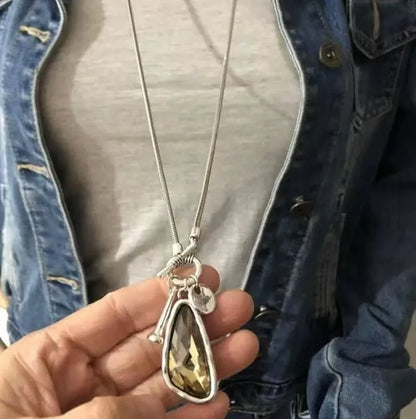 Women's geometric alloy pendant on a long snake bone chain necklace in blue, champagne, or grey.