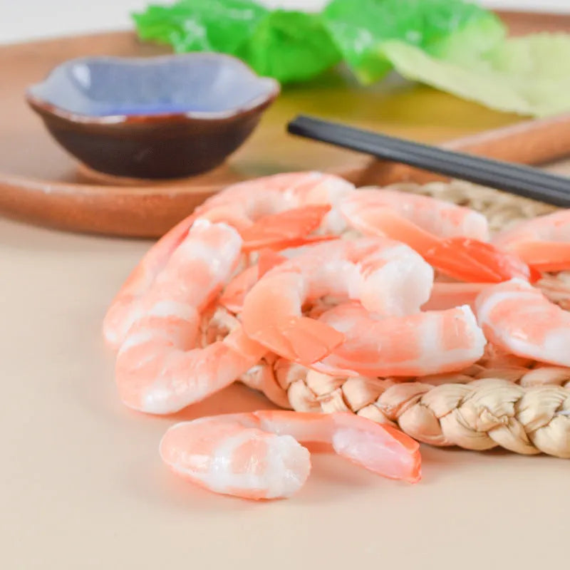 White PVC shrimp-shaped keychain with door buckle on a blue background.