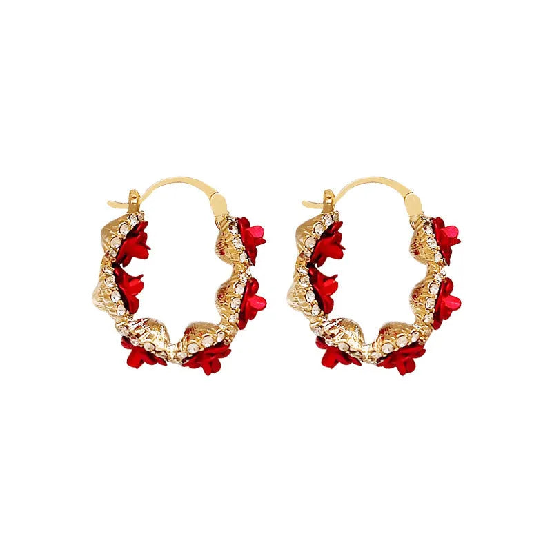 A pair of red rose-shaped clip-on alloy earrings for women on a white background.