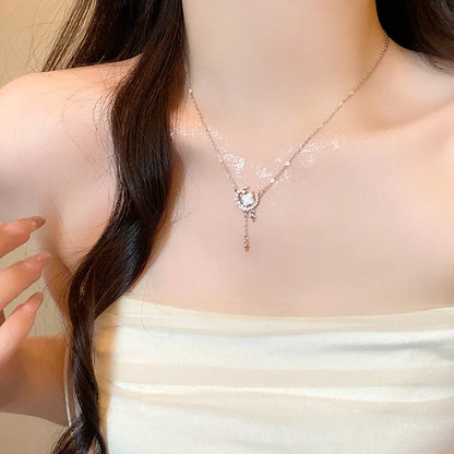 Gold star and moon zirconium necklace on a model, showing adjustable chain length.