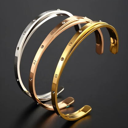 Open-ended women's bracelet with inlaid zircon stones on a stainless steel band in a gold colour finish.