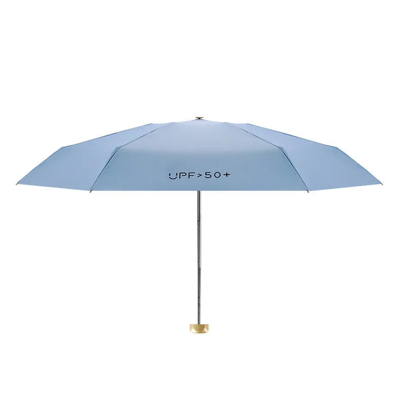 Compact flat-folded sun umbrella in a solid colour, shown next to a hand for scale.