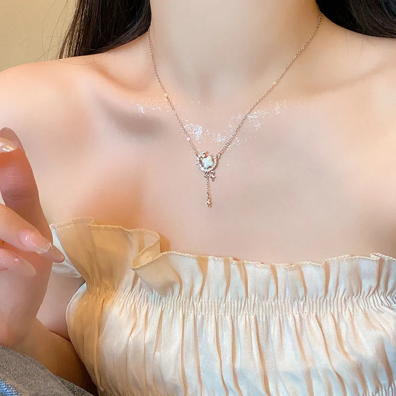 Gold star and moon zirconium necklace on a model, showing adjustable chain length.