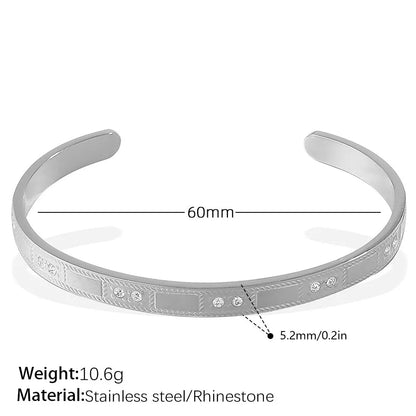 Stainless steel open-end bracelet with a buckle clasp in a choice of gold, silver, or zirconium gold electroplated finishes.