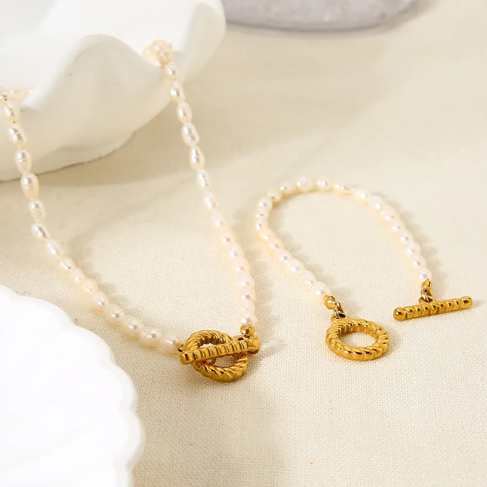 Freshwater pearl and stainless steel geometric pendant necklace with matching bracelet set.