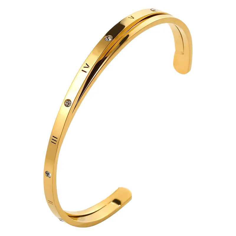 Open-ended women's bracelet with inlaid zircon stones on a stainless steel band in a gold colour finish.