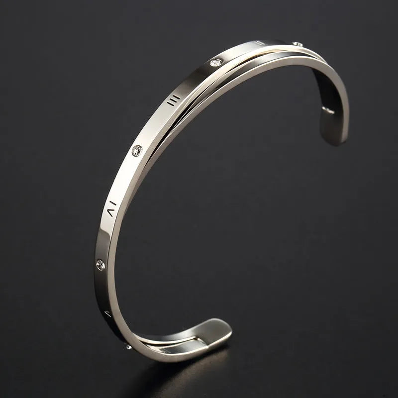 Open-ended women's bracelet with inlaid zircon stones on a stainless steel band in a gold colour finish.