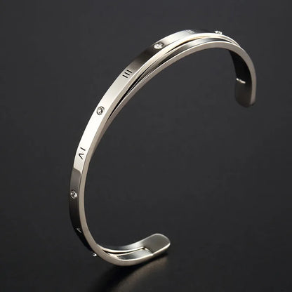 Open-ended women's bracelet with inlaid zircon stones on a stainless steel band in a gold colour finish.