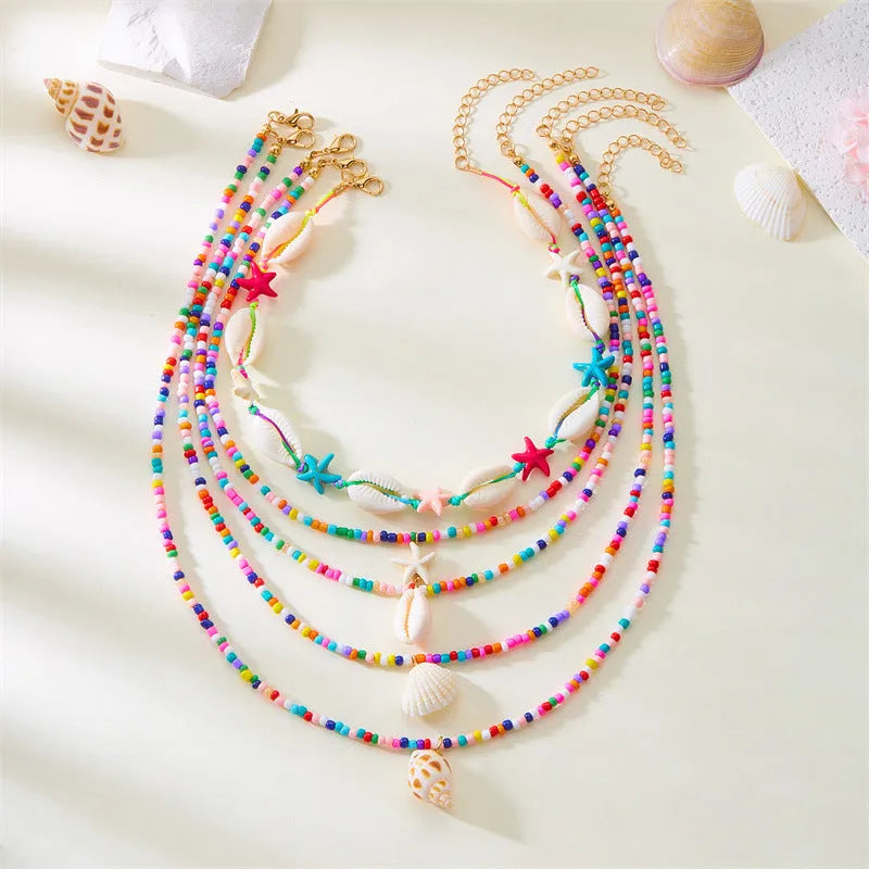Five women's necklaces with starfish shell beads on adjustable chains in summer colours