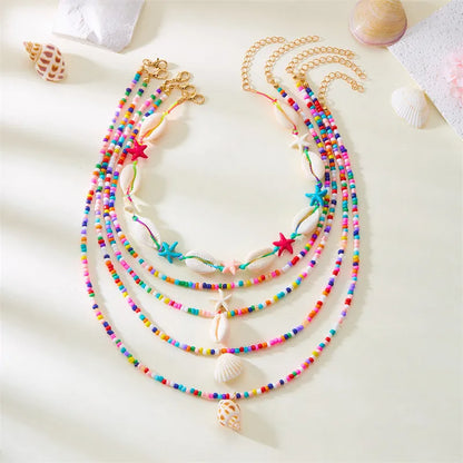 Five women's necklaces with starfish shell beads on adjustable chains in summer colours