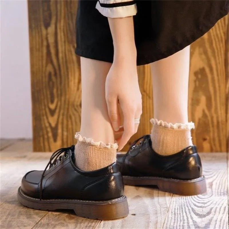 Black retro women's Mary Jane shoes with lace-up front and low square heel on a white background.
