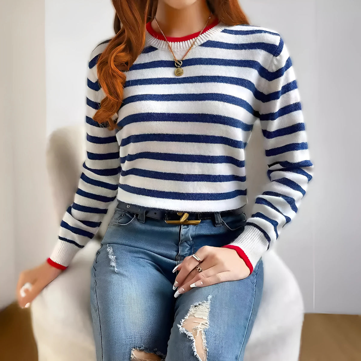 Sapphire blue striped knitted pullover sweater with round neck and long sleeves on a hanger.