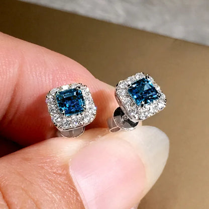 A pair of square cut grandmother green zircon stud earrings with a gold electroplated finish on a white background.